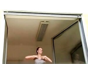 Short haired girl washes windows topless