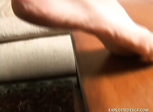 Stacked brunette teen Mia sits on the couch and rubs lotion on her tiny sexy feet